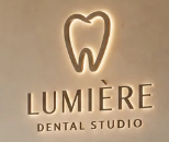 A close-up of the backlit LUMIÈRE signage inside the studio